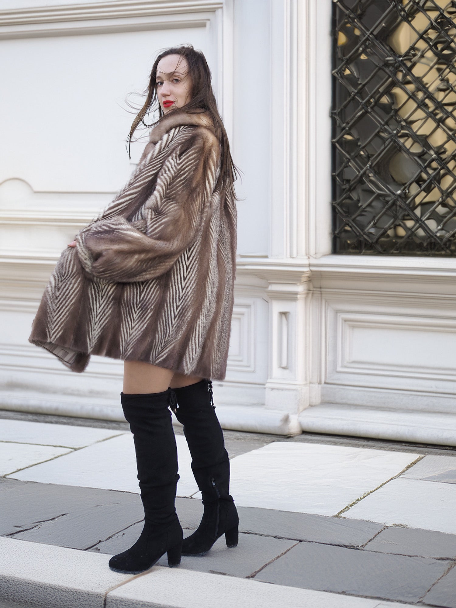 Model walking in Canadian Mink Fur Jacket L/XL 16, styled with a black mini dress and boots for a chic winter look.