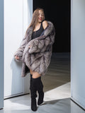 Woman wearing a fur coat and black boots in a doorway.