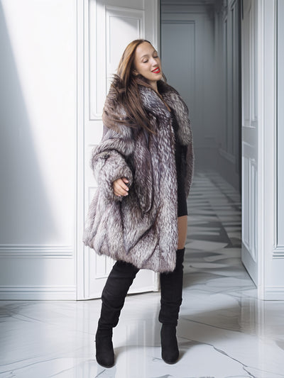 Woman wearing a fur coat in a hallway with white walls and marble floor.