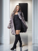 Woman wearing a fur coat and black dress in a modern interior setting