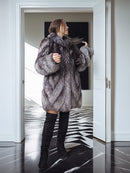 Person wearing a fur coat in a modern interior setting