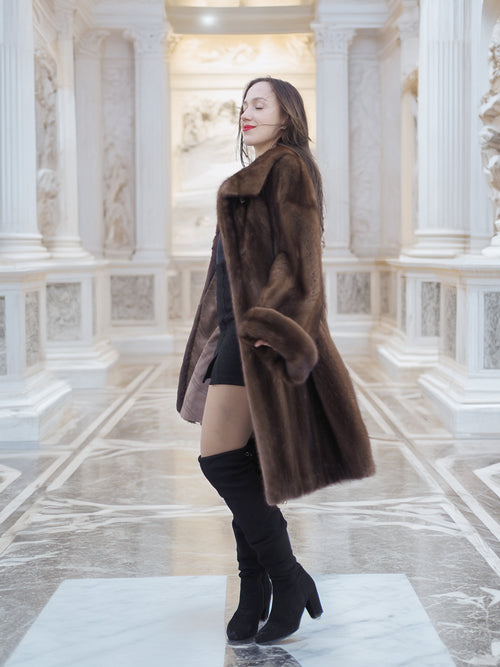 Model posing in Brand New Luxurious Demi Buff Swing Canadian Mink Fur Coat L/XL, surrounded by ornate white marble architecture.