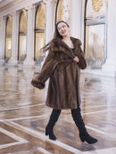 Model smiling in Brand New Luxurious Demi Buff Swing Canadian Mink Fur Coat L/XL, styled for elegance in a gold-accented hall.