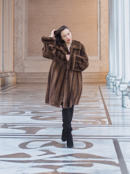 Model posing in Brand New Luxurious Demi Buff Swing Canadian Mink Fur Coat L/XL, styled with black boots in a marble corridor.