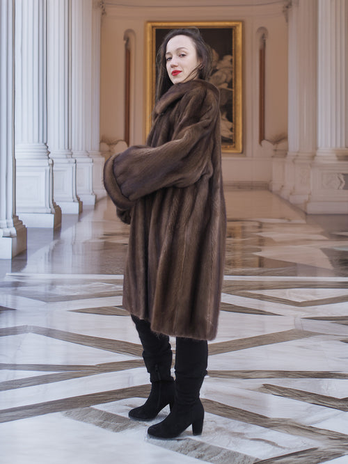 Model posing in Brand New Luxurious Demi Buff Swing Canadian Mink Fur Coat L/XL, styled in a grand hall with classical artwork.