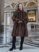 Model standing in ornate hall wearing Brand New Luxurious Demi Buff Swing Canadian Mink Fur Coat L/XL, styled with black boots.
