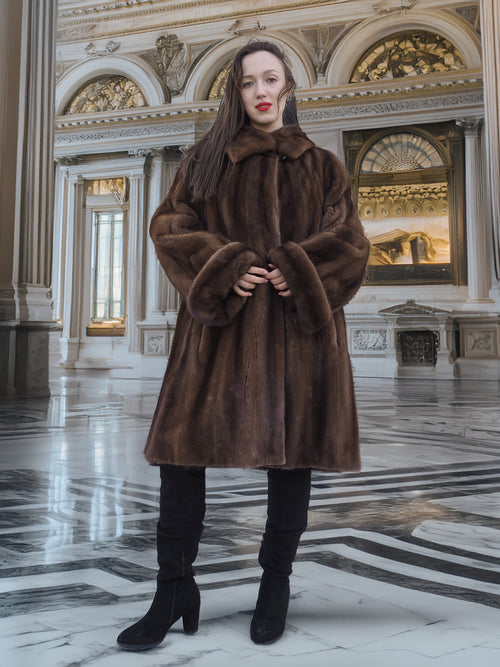 Model standing in ornate hall wearing Brand New Luxurious Demi Buff Swing Canadian Mink Fur Coat L/XL, styled with black boots.