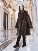 Side view of Brand New Luxurious Demi Buff Swing Canadian Mink Fur Coat L/XL, styled with black boots in a grand marble interior.