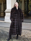 Timeless mahogany mink fur coat styled with black boots, offering a sophisticated winter look. A luxurious and warm outerwear piece.