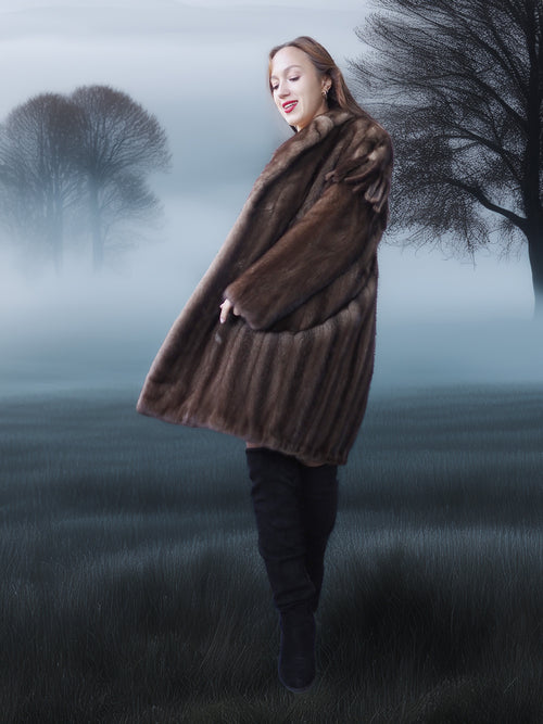 Woman in a fur coat standing in a foggy, tree-lined field