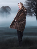 Woman in a fur coat standing in a foggy, tree-lined field