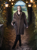 Woman in a fur coat standing in a lit pathway with greenery on either side