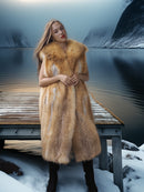 Woman in a fur coat standing on a snowy dock with mountains in the background