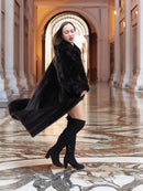 Luxury black mink coat in motion, highlighting its dramatic sweep and rich texture, ideal for upscale winter fashion statements.