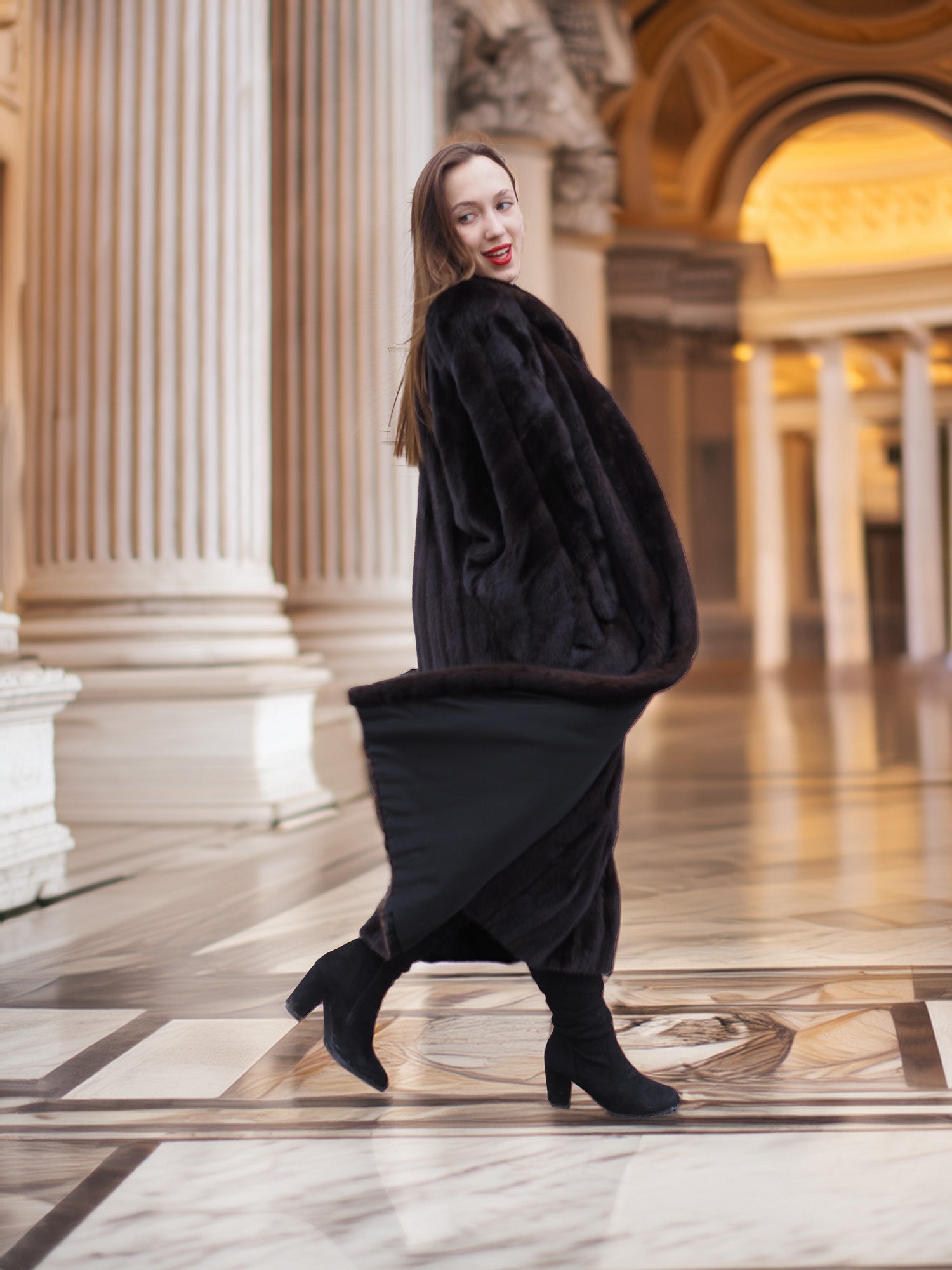 Model steps forward in flowing black mink coat, blending motion and luxury for a bold winter fashion statement.