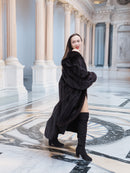 Model turns in black mink coat in marble hall, showcasing luxurious fur movement and timeless cold-weather elegance.