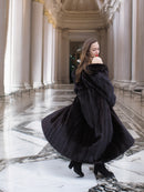 Model twirls in full-length black mink coat, revealing its voluminous design and luxurious movement for winter elegance.