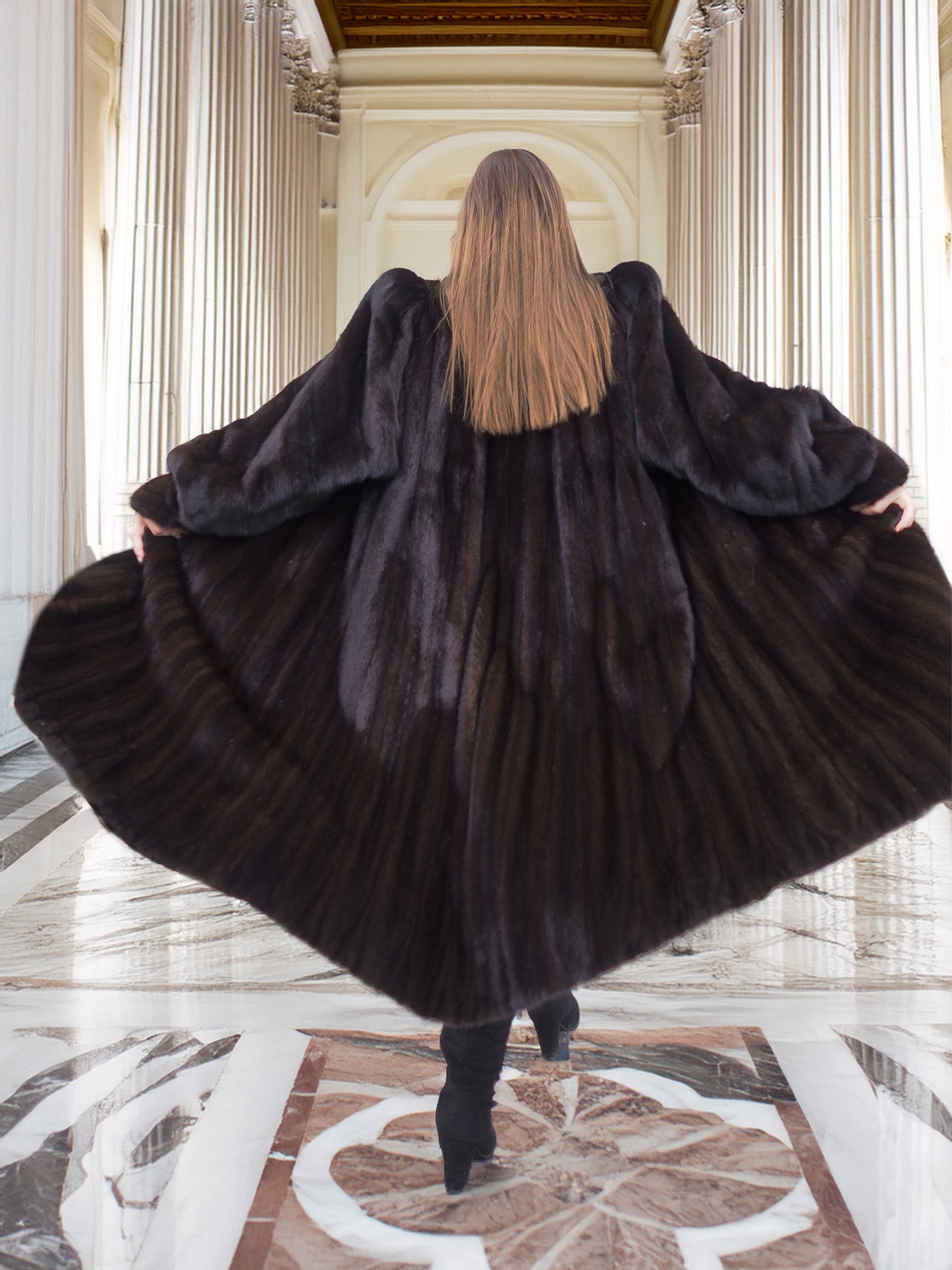 Back view of black mink coat with flared hem, showcasing natural fur texture and dramatic silhouette in luxury fashion.