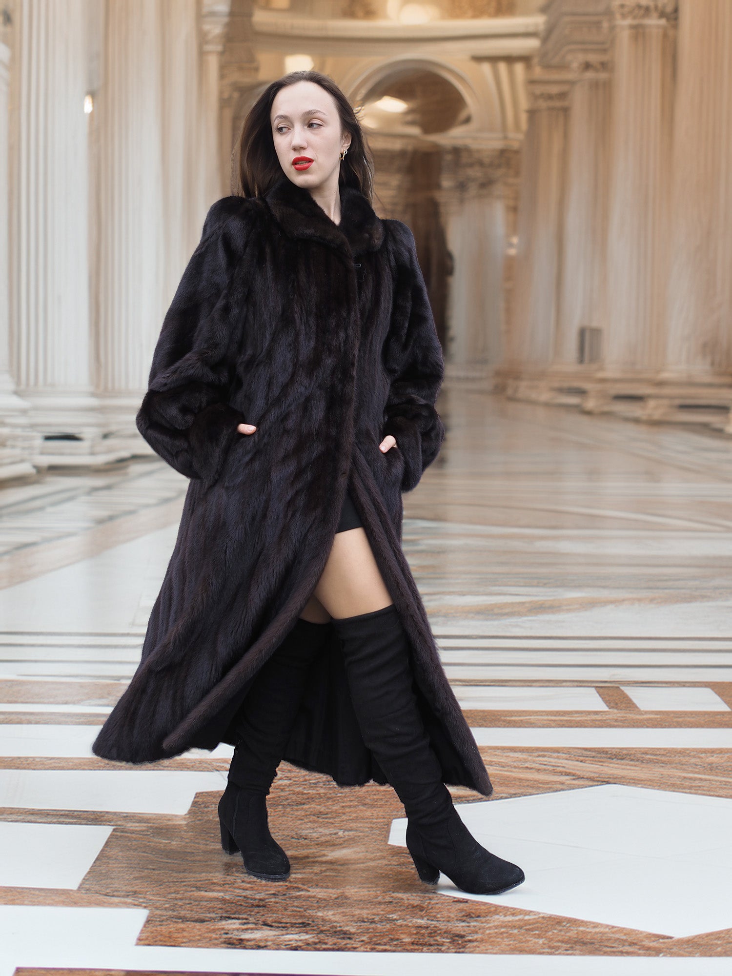 Model strides in black mink coat with thigh-high boots, blending modern allure with classic fur fashion elegance.
