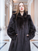 Close-up of model in black mink coat with hands in pockets, highlighting rich fur texture and elegant winter style.