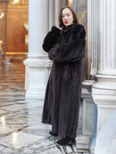 Black mink fur coat styled in a regal corridor, emphasizing warmth, luxury, and sophistication in winter outerwear.