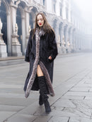 Walking confidently in black mink coat with indigo fox collar, paired with thigh-high boots for a bold winter outfit.