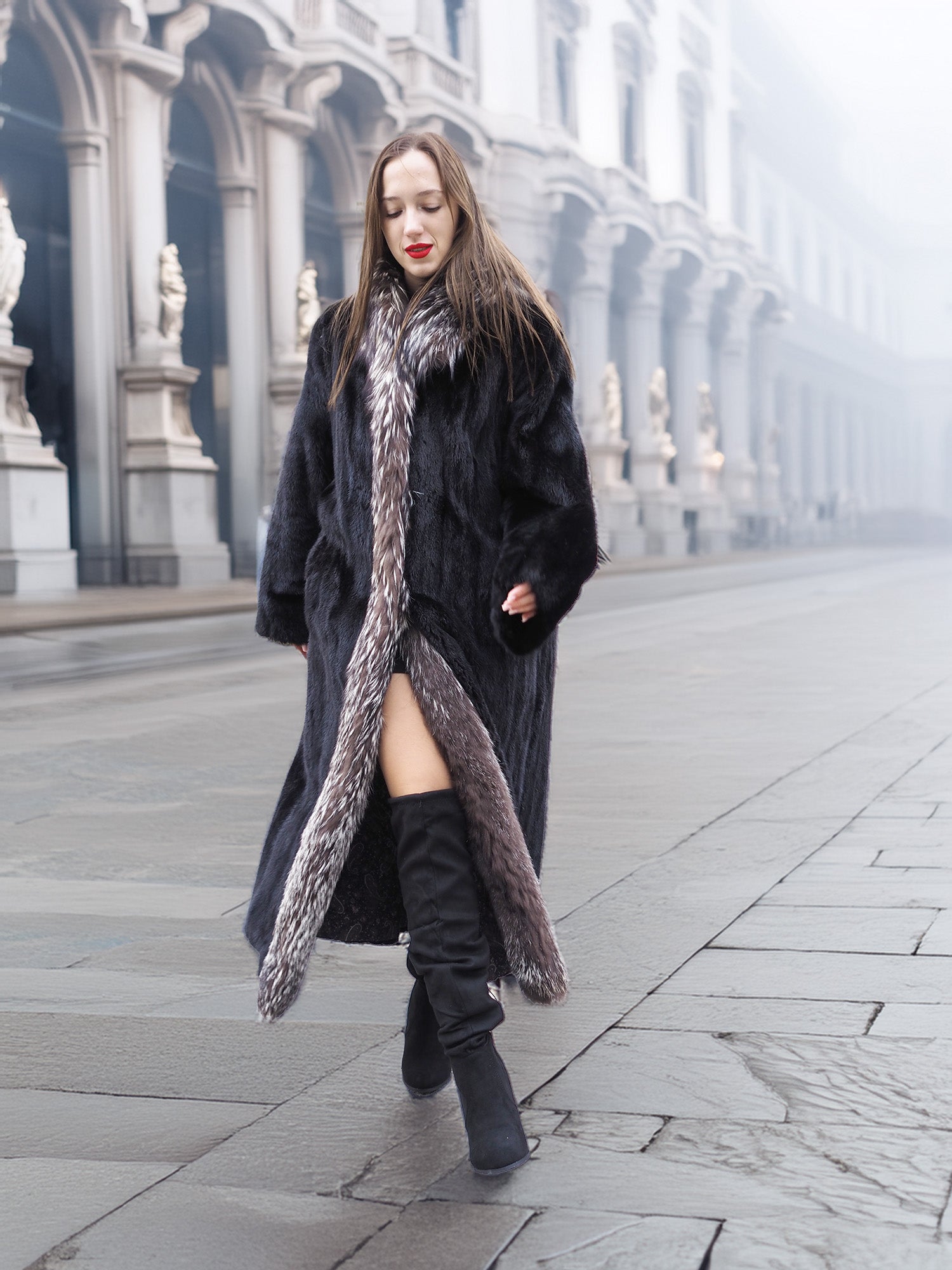 Walking confidently in black mink coat with indigo fox collar, paired with thigh-high boots for a bold winter outfit.
