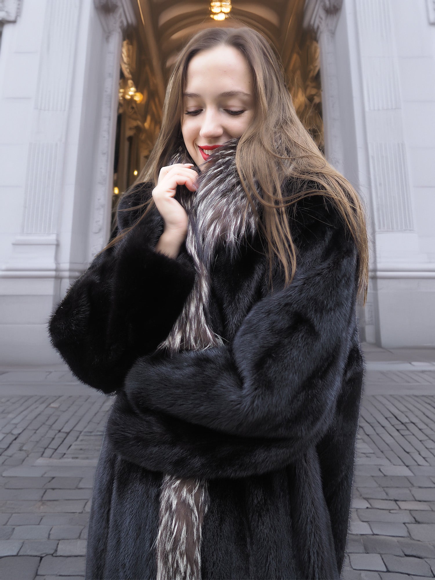 Close-up of black mink coat with indigo fox collar, emphasizing plush texture and cozy winter elegance.