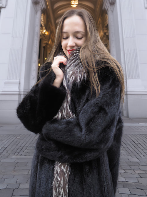 Close-up of black mink coat with indigo fox collar, emphasizing plush texture and cozy winter elegance.