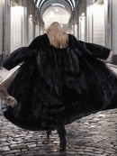 Back view of black mink coat with indigo fox collar, showcasing voluminous silhouette and premium fur quality for cold-weather elegance.