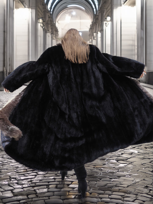 Back view of black mink coat with indigo fox collar, showcasing voluminous silhouette and premium fur quality for cold-weather elegance.
