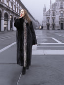 Elegant black mink coat with silver fox trim, worn in a foggy cityscape for a sophisticated winter outerwear look.