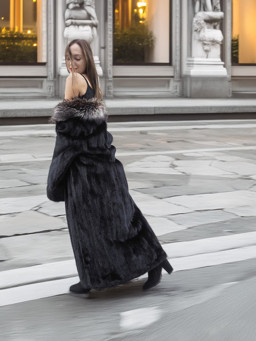 Black mink coat with indigo fox collar in motion, styled over a mini dress and boots for luxury winter fashion.