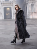 Walking pose in black mink coat with indigo fox collar, showcasing movement and luxurious fur texture for winter fashion.