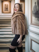 Woman wearing a fur stole in an elegant interior setting