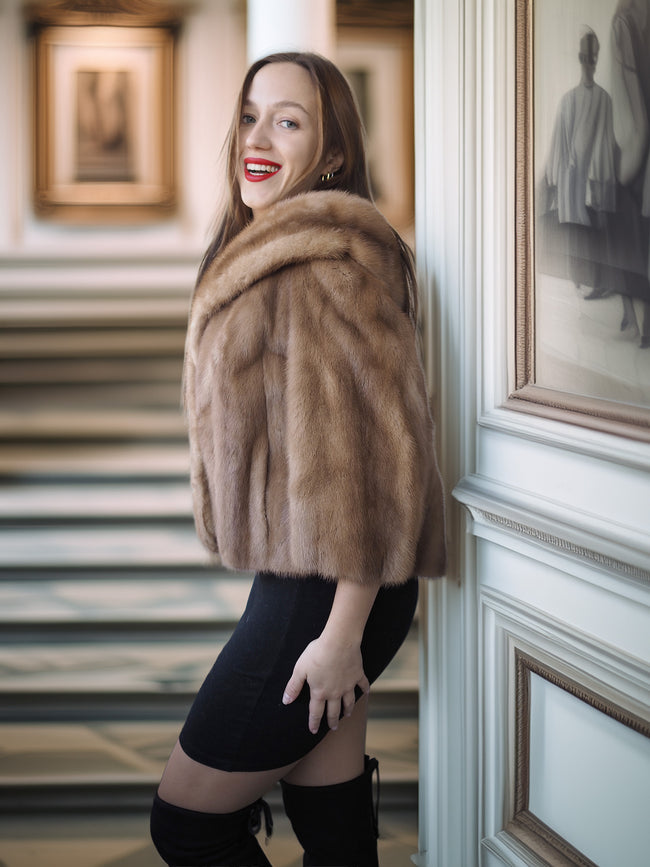 Woman wearing a fur stole in an elegant interior setting
