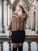 Woman wearing a fur coat in an elegant interior setting