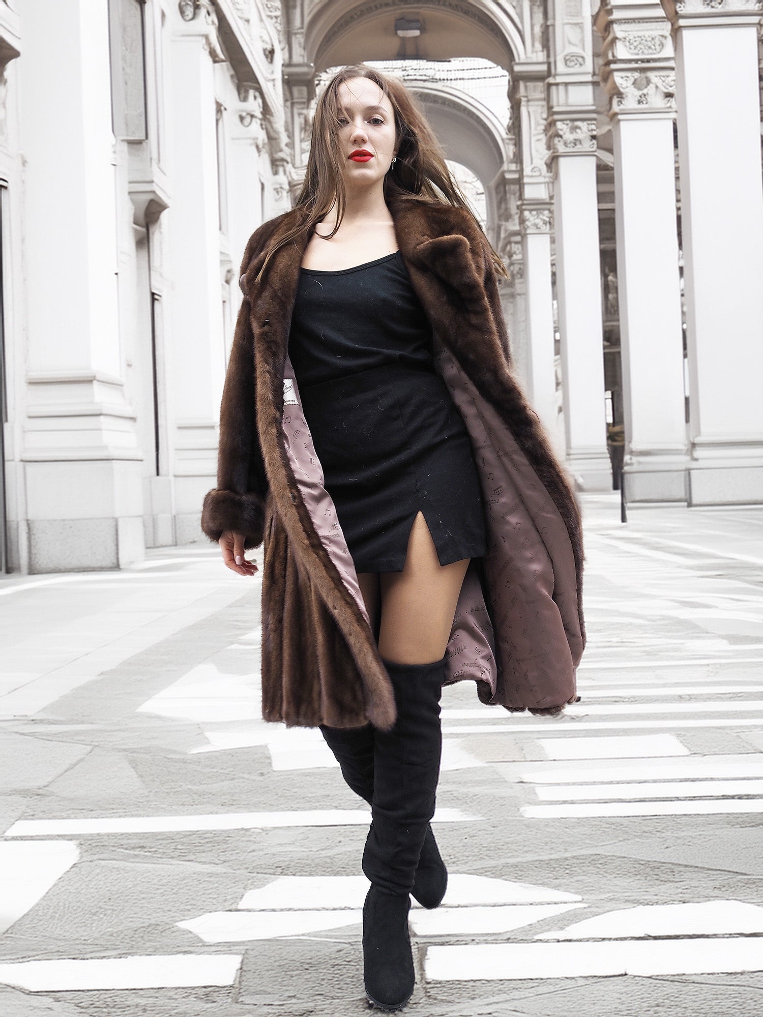 Model striding confidently in open vintage mink fur coat, revealing inner lining and stylish winter outfit.