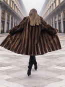 Back view of flared vintage mink fur coat in mahogany brown, showcasing premium fur texture and full silhouette.