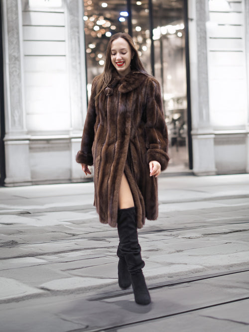 Woman walking in a luxurious dark mahogany mink fur coat, showcasing premium vintage outerwear for cold weather fashion.