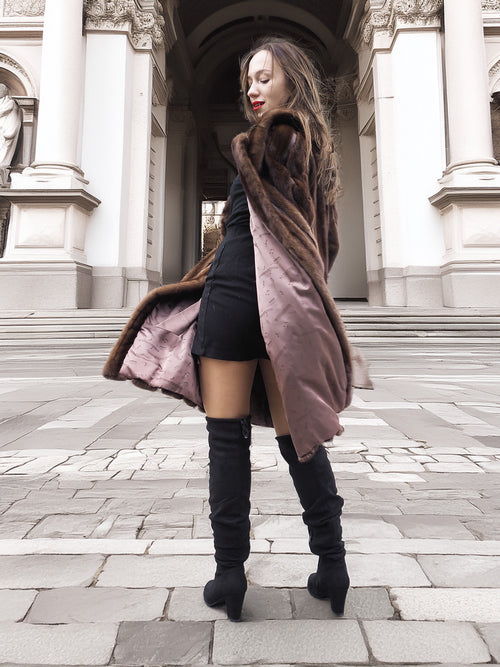Model twirling in open vintage mink fur coat, revealing silky brown lining and elegant craftsmanship in outerwear design.