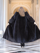 Back view of black mink fur coat flared out in motion, emphasizing its full volume and luxury. Premium winter outerwear, size M.