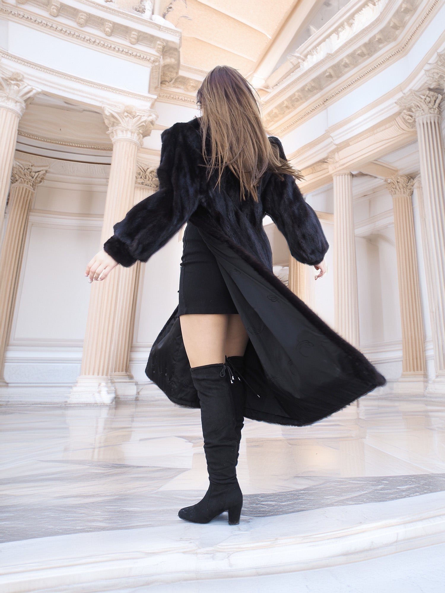 Model spinning in black mink fur coat over a black mini dress, highlighting coat's inner lining. Chic winter layering piece, size M.