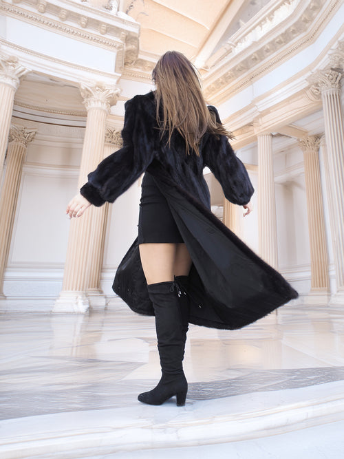 Model spinning in black mink fur coat over a black mini dress, highlighting coat's inner lining. Chic winter layering piece, size M.