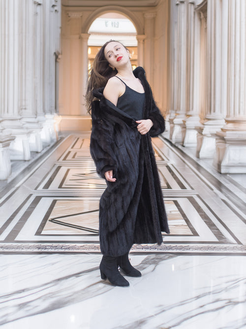 Black mink fur coat worn open over a black dress, revealing inner lining. Luxurious winter outerwear for stylish layering, size M.