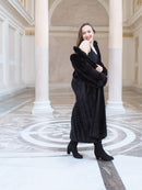 Model smiling in black mink fur coat worn off one shoulder, styled with black boots. Full-length fur fashion for winter, size M.