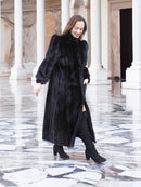 Model walking in black mink fur coat with front slit, paired with black boots. Full-length luxury fur outerwear, size M.