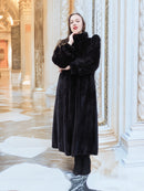 Black mink fur coat with voluminous silhouette and soft texture, styled in a golden interior. Luxury fur outerwear for cold seasons, size M.