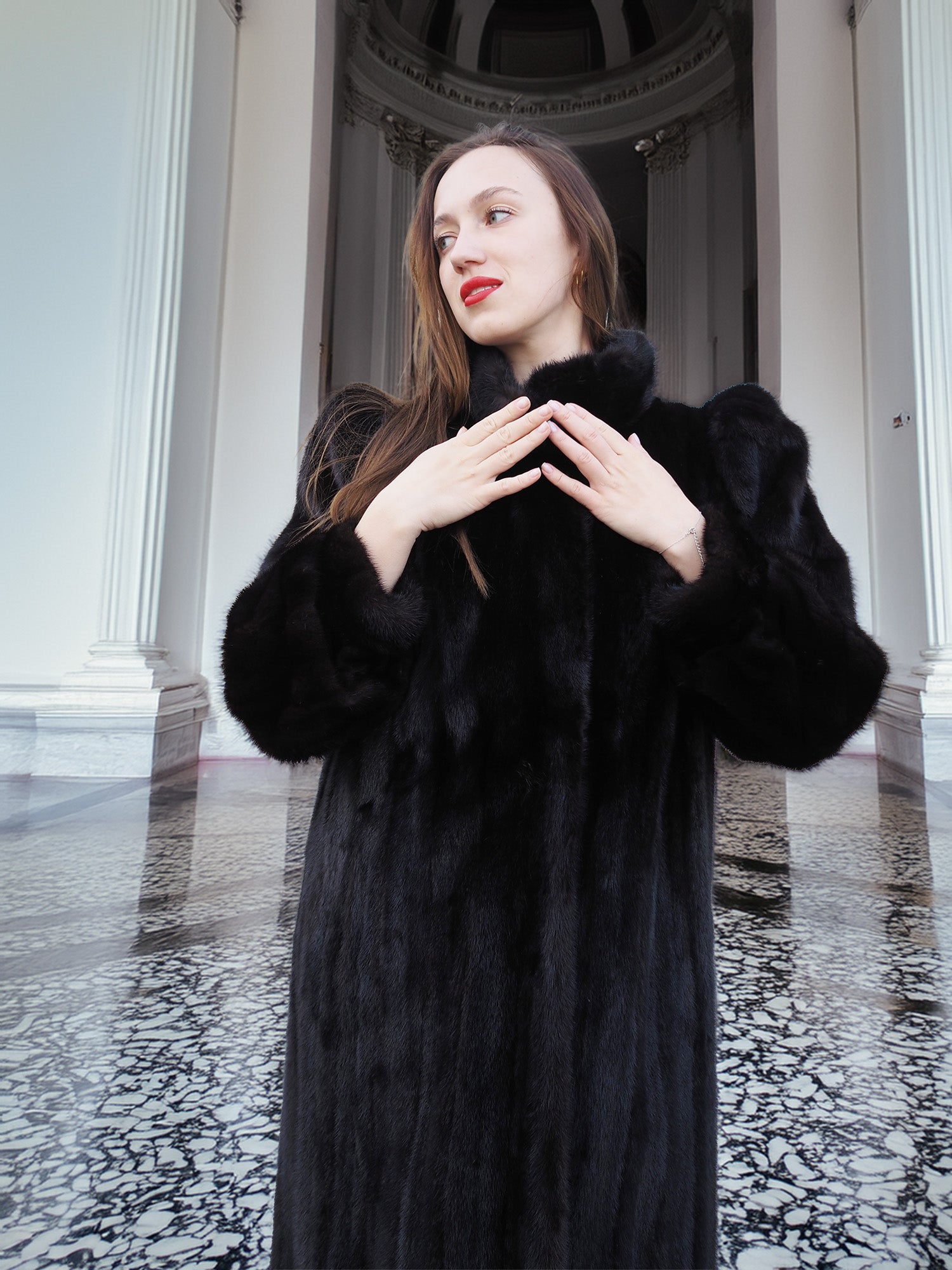 Model in black mink fur coat with hands raised, showcasing plush sleeves and elegant cut. Full-length winter coat, size M.
