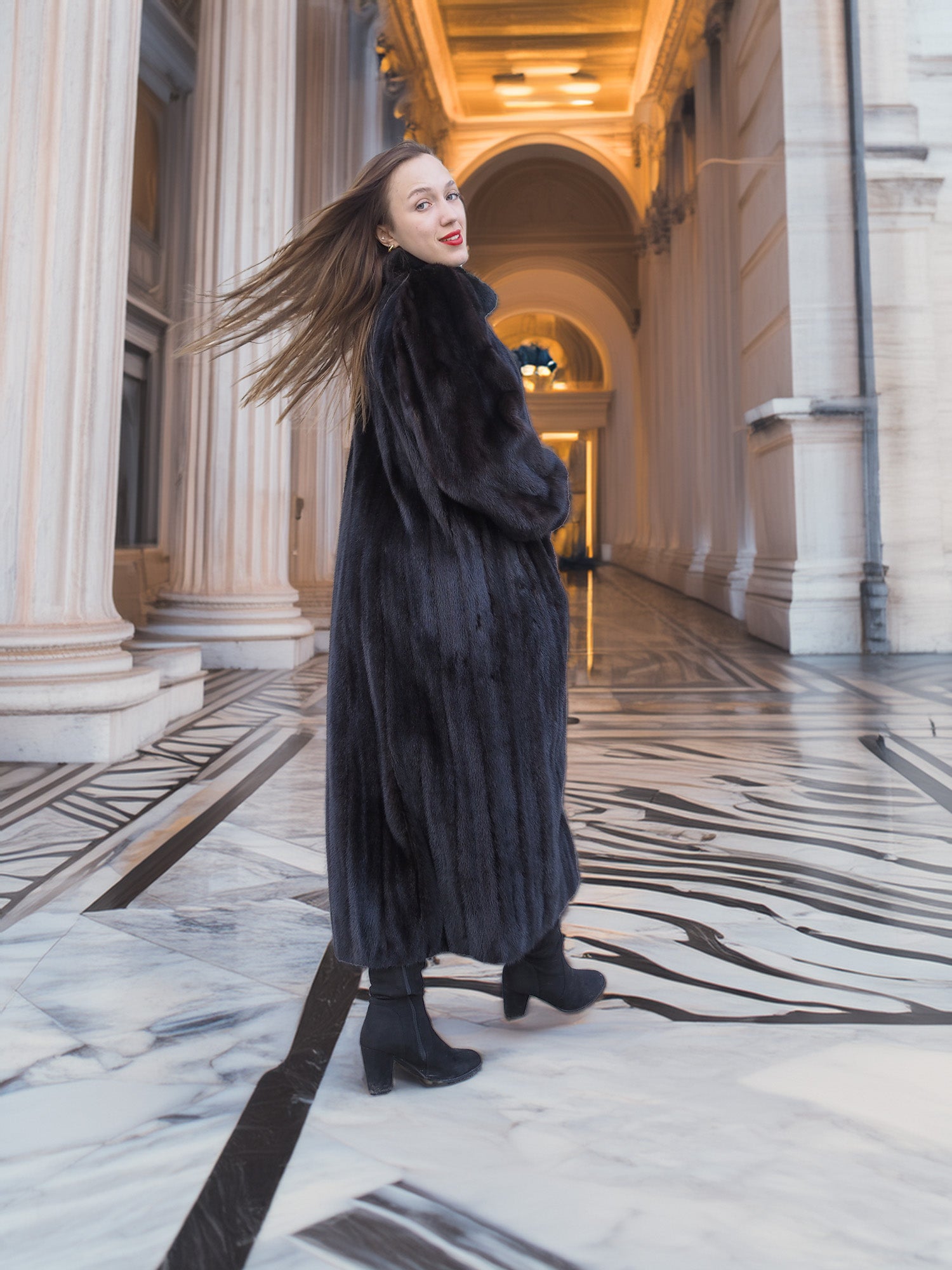 Model twirling in full-length black mink fur coat, showcasing rich texture and movement. Elegant winter outerwear, size M.